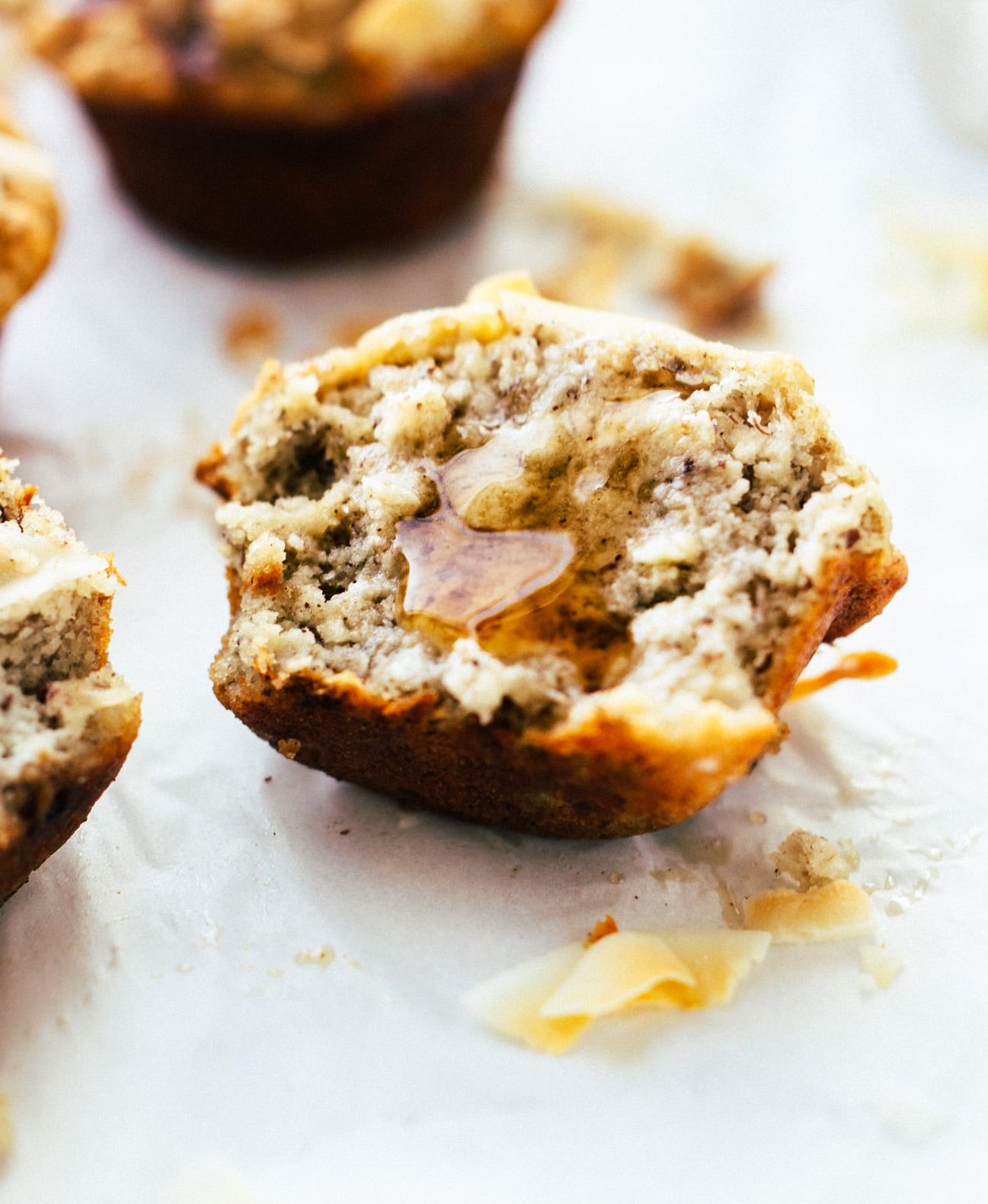 Half of an almond flour banana muffin topped with a drizzle of honey