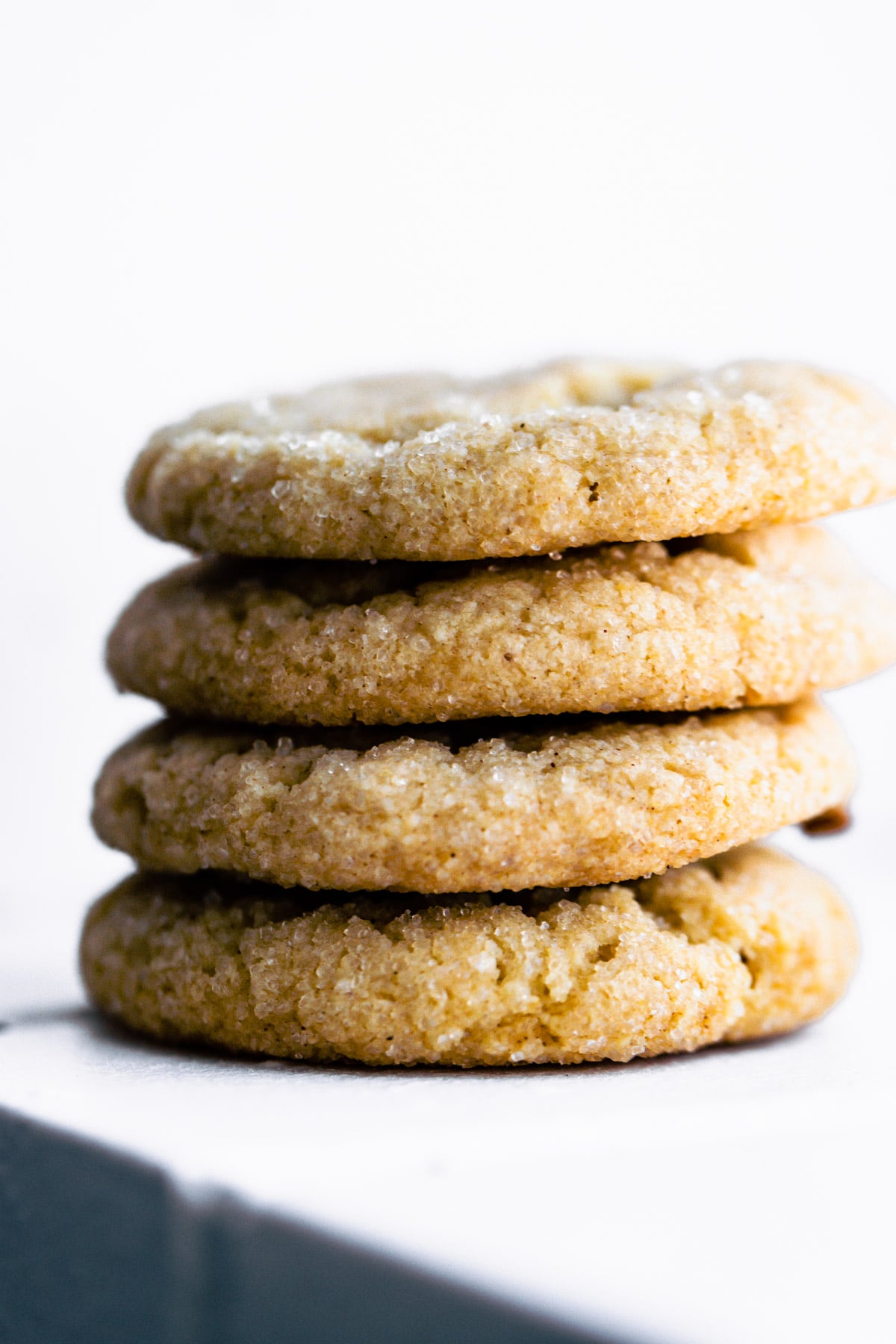 Almond flour sugar cookies stacked up on each other sprinkled with sugar crystals