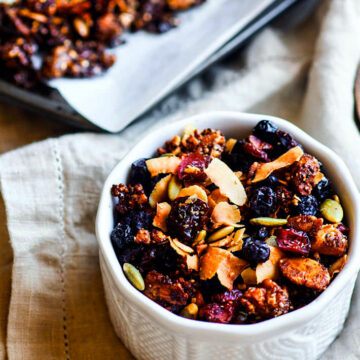 Toasted Coconut and Berry Grain Free Granola! A super simple homemade vegan and paleo grain free granola recipe that tastes so good! An assortment of Nuts, seeds, dried berries, spices, coconut oil, coconut, and maple syrup all baked up, that's it! Perfectly filling and EASY to throw together! Great fuel for you or a gift ideas for others. www.cottercrunch.com