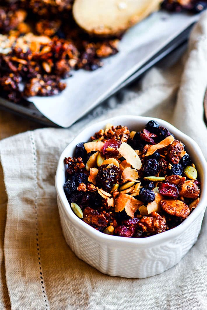 Toasted Coconut and Berry Grain Free Granola! A super simple homemade vegan and paleo grain free granola recipe that tastes so good! An assortment of Nuts, seeds, dried berries, spices, coconut oil, coconut, and maple syrup all baked up, that's it! Perfectly filling and EASY to throw together! Great fuel for you or a gift ideas for others. www.cottercrunch.com