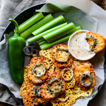 Cheese crisps topped with jalapeno slices on a platter