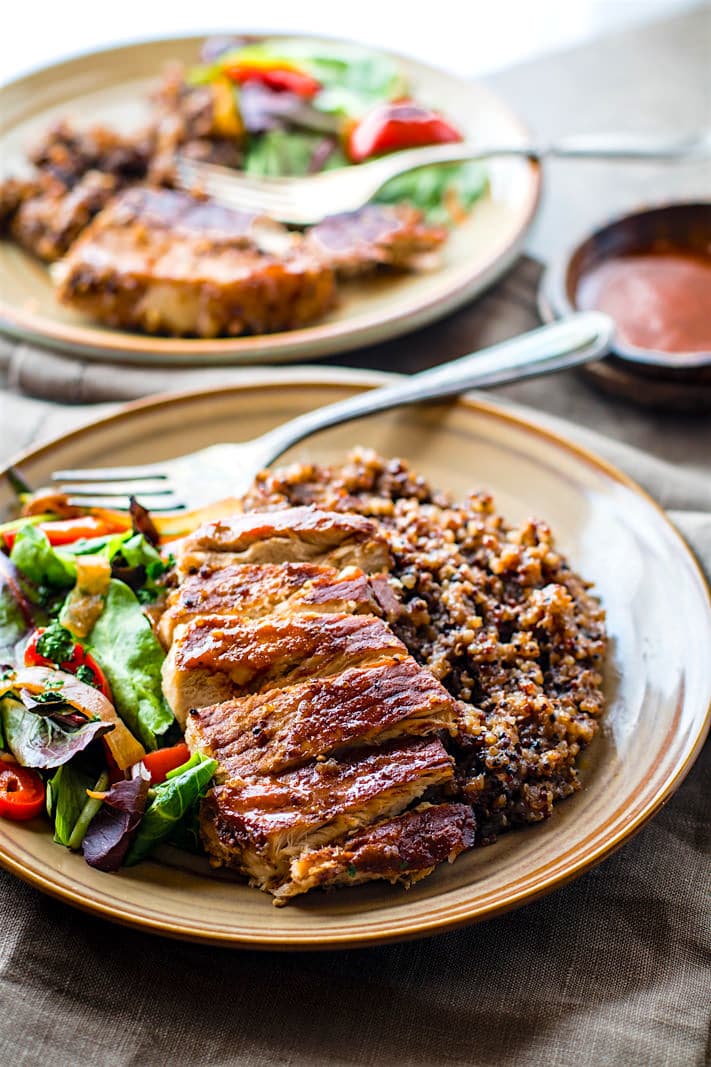 plates of gluten free BBQ pork chops, salad, and quinoa