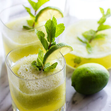 3 glasses filled with mint melon limeade and fresh min to garnish