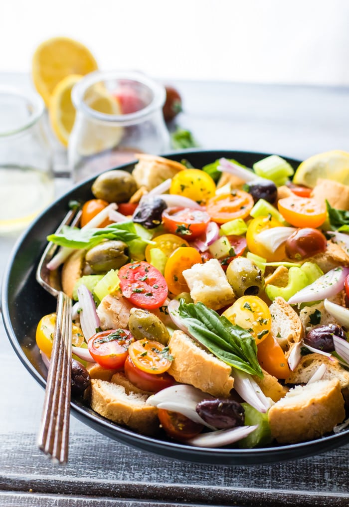 Toasted Panzanella Salad bowls! This popular Italian Panzanella salad is the perfect healthy bowl to any meal or even as a vegetarian main! Toasted Crusty gluten free bread combined with juice tomatoes, vegetables, and olives, all soaked in a zesty dressing. Oh my! This Panzanella salad, is light, refreshing, and dairy free.