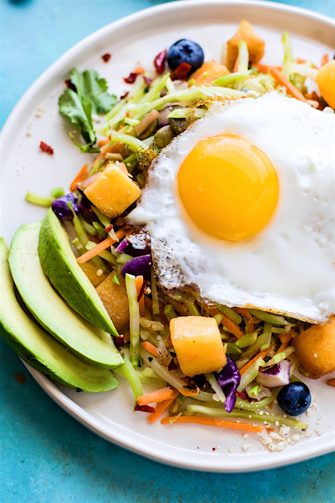 Breakfast salads are the best way to start the day! Create a healthy warm Paleo morning meal with lightly cooked broccoli cole slaw, onion, and squash topped with seasonal fruit and a protein rich fried egg! A nourishing breakfast salad worth waking up for! Easy, delicious, nutritious!