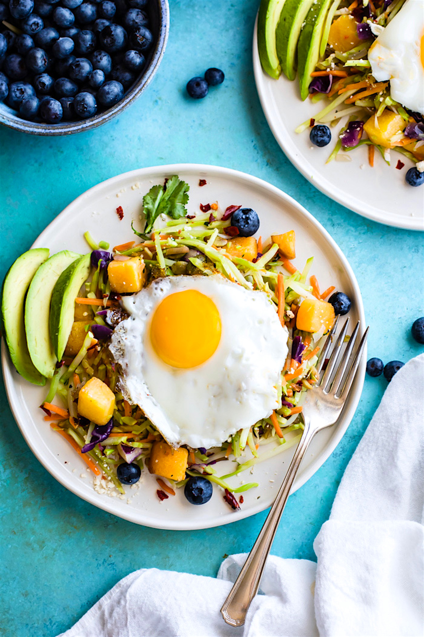 Breakfast salads are the best way to start the day! Create a healthy warm Paleo morning meal with lightly cooked broccoli cole slaw, onion, and squash topped with seasonal fruit and a protein rich fried egg! A nourishing breakfast salad worth waking up for! Easy, delicious, nutritious!