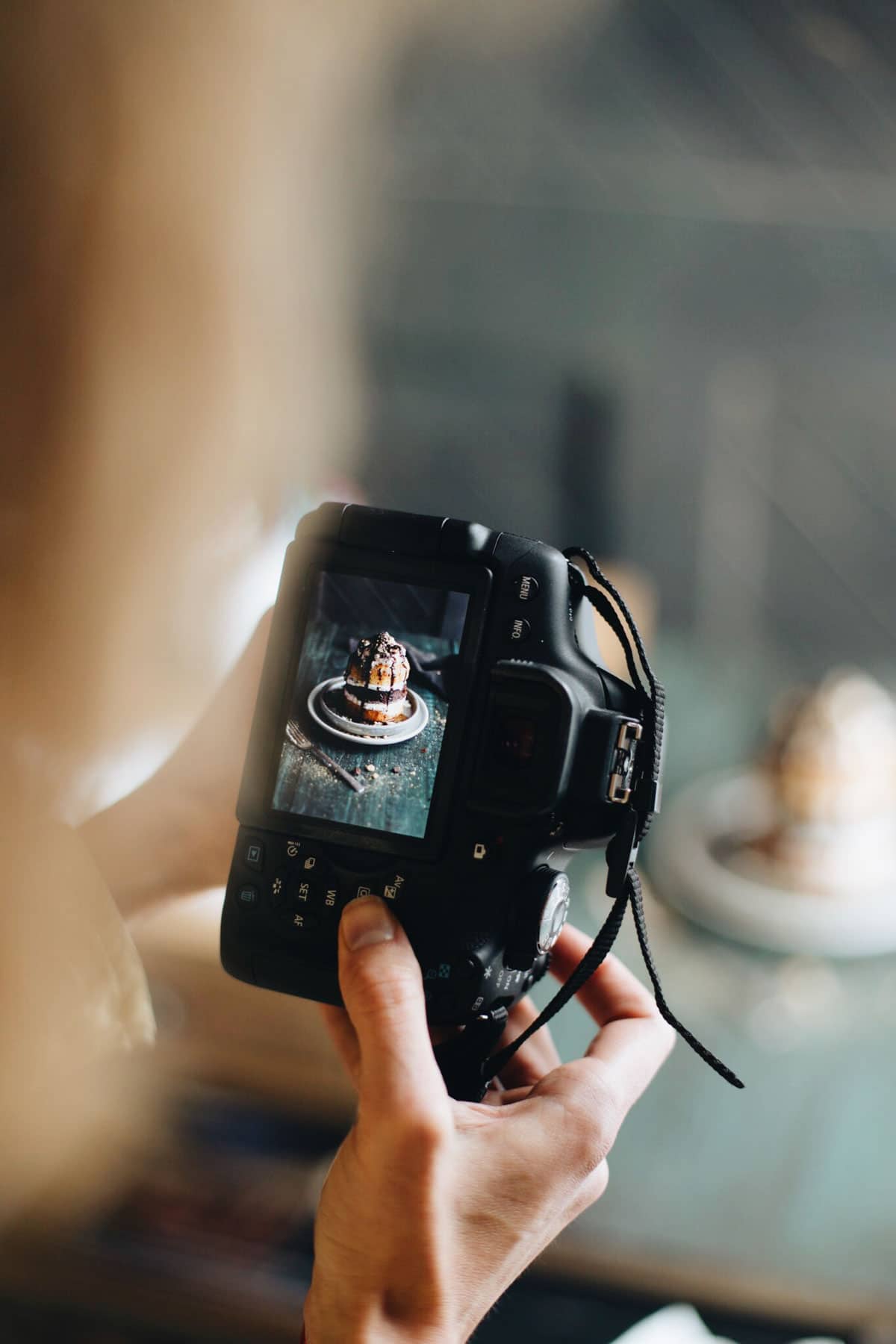 DSLR camera with image of layered cake on screen.