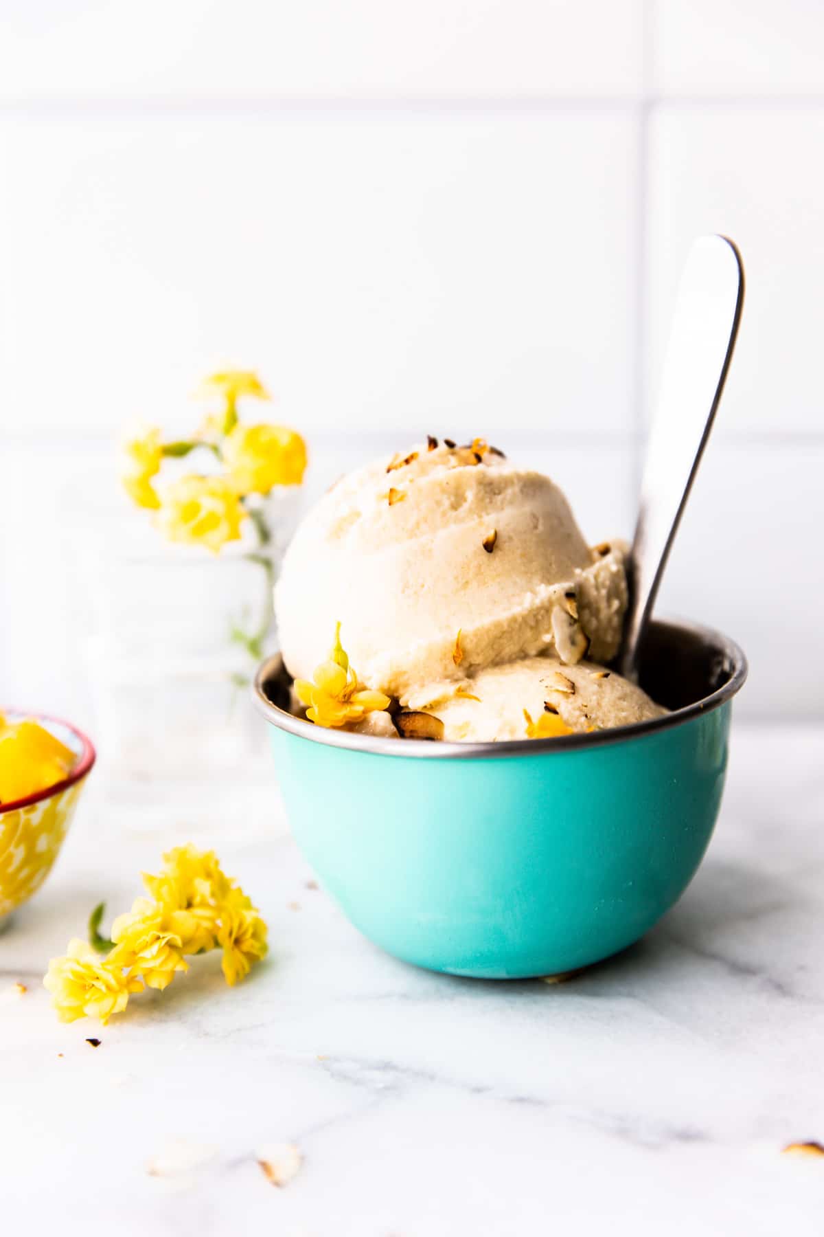 2 scoops of banana coconut milk nice cream in robin's egg blue ice cream bowl with spoon