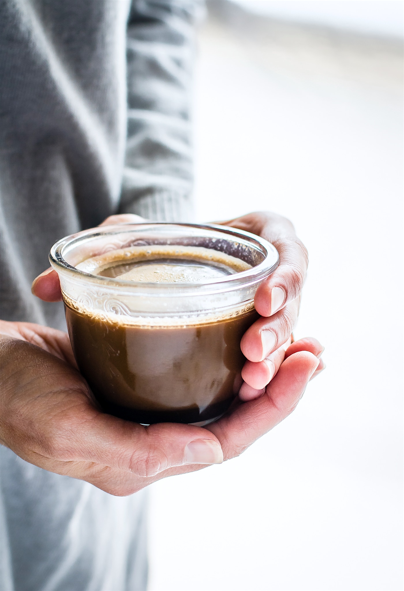 Woman holding mug of vegan hazelnut Turkish coffee.