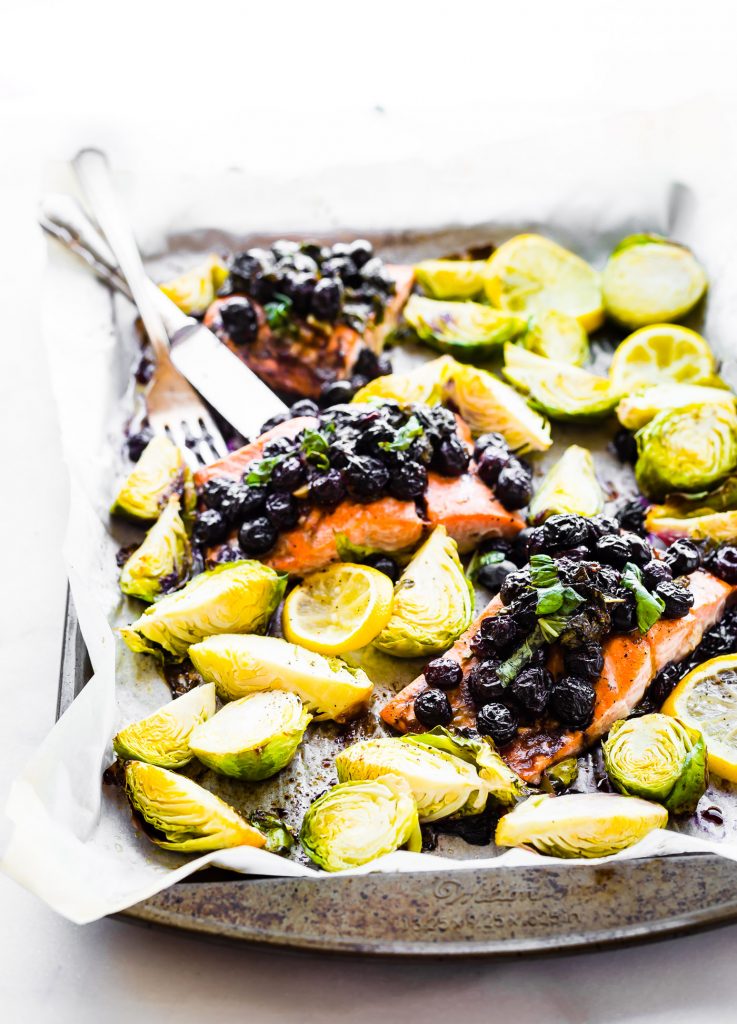 One pan Paleo SUPERFOOD Baked Salmon is ready in 20 minutes and packed full of nutrients. A nourishing, whole 30 friendly, flavorful meal! Salmon baked with a zippy basil blueberry balsamic topping and crispy Brüssels sprouts!