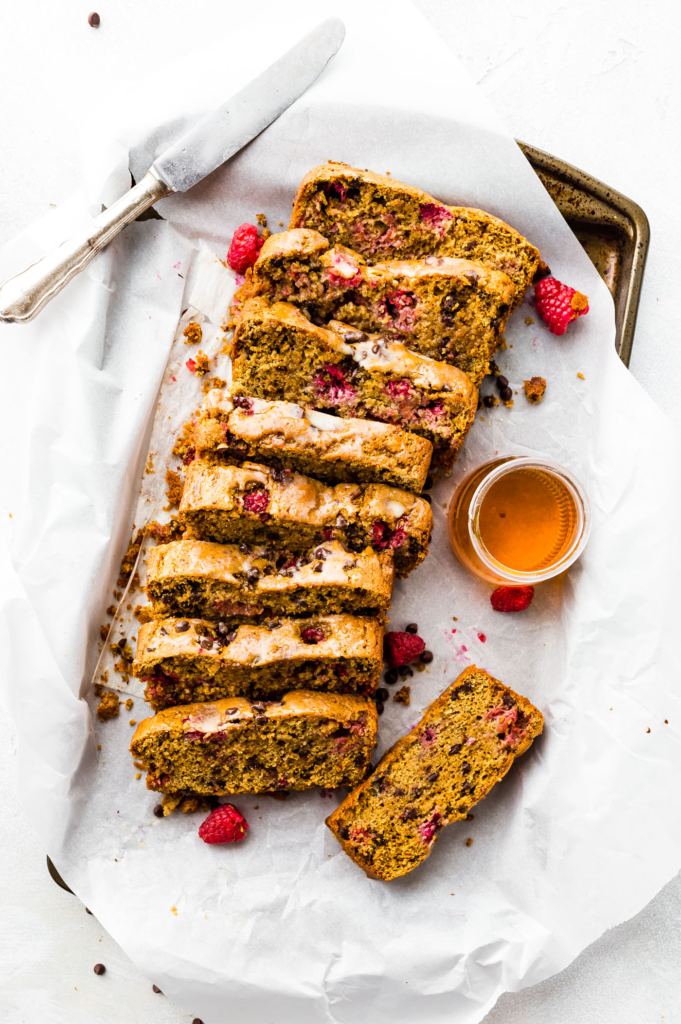 loaf of gluten free chocolate raspberry pancake bread cut into thick slices on parchment lined baking sheet.