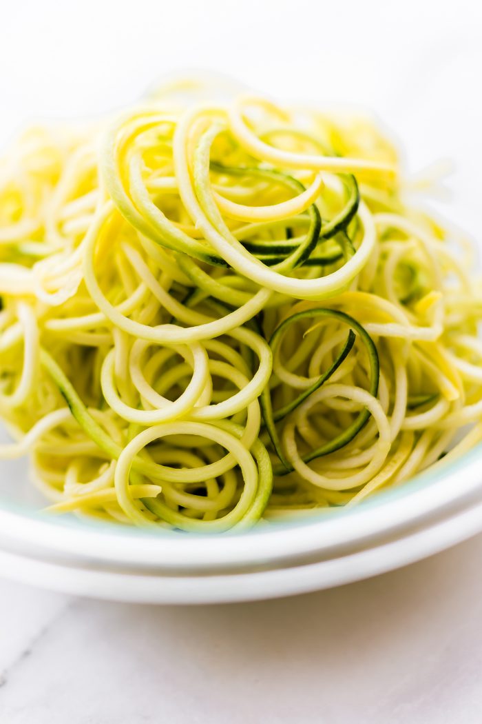 Close up view tall pile of spiralized zucchini noodles.