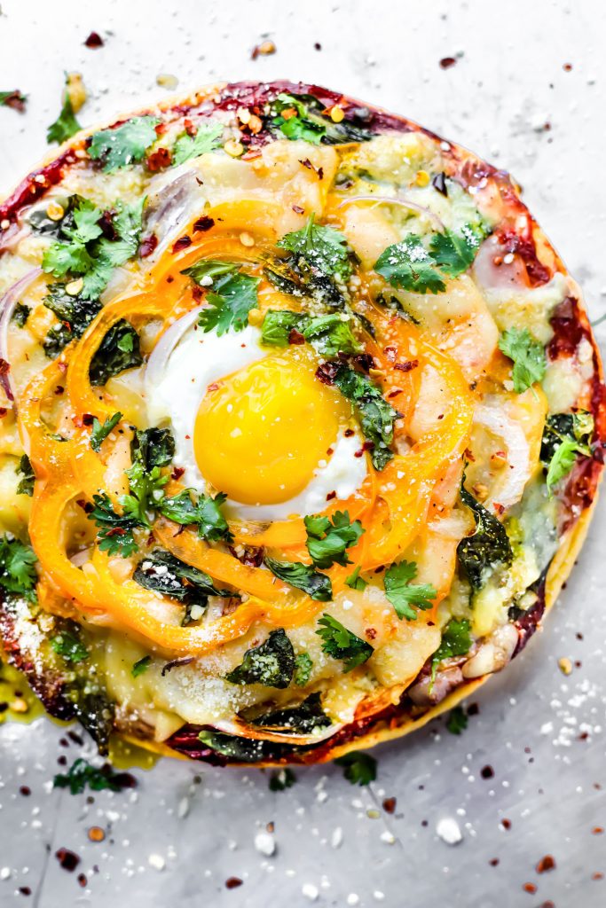 A breakfast pizza recipe you can make for any meal! Socca pizza crust made from just 3 ingredients, sliced pineapple, uncured bacon, egg, onion, and creamy meltable artisan cheese! A breakfast pizza that's quick to make, grain free, and deliciously nutritious. You'll be hooked!