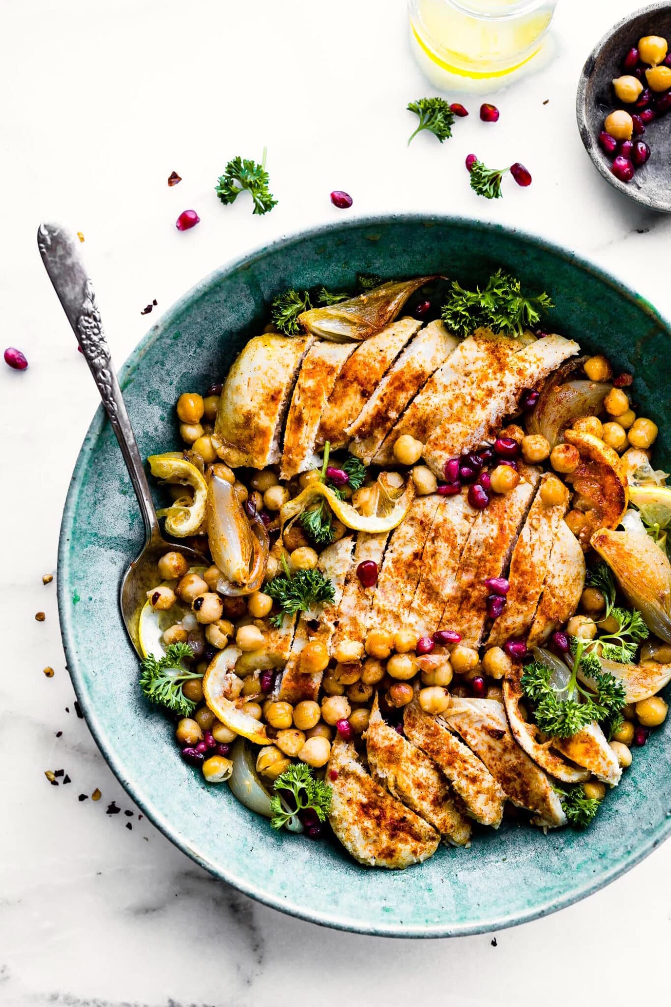 Overhead view cumin roasted chickpea chicken bowls with slices chicken in turquoise bowl