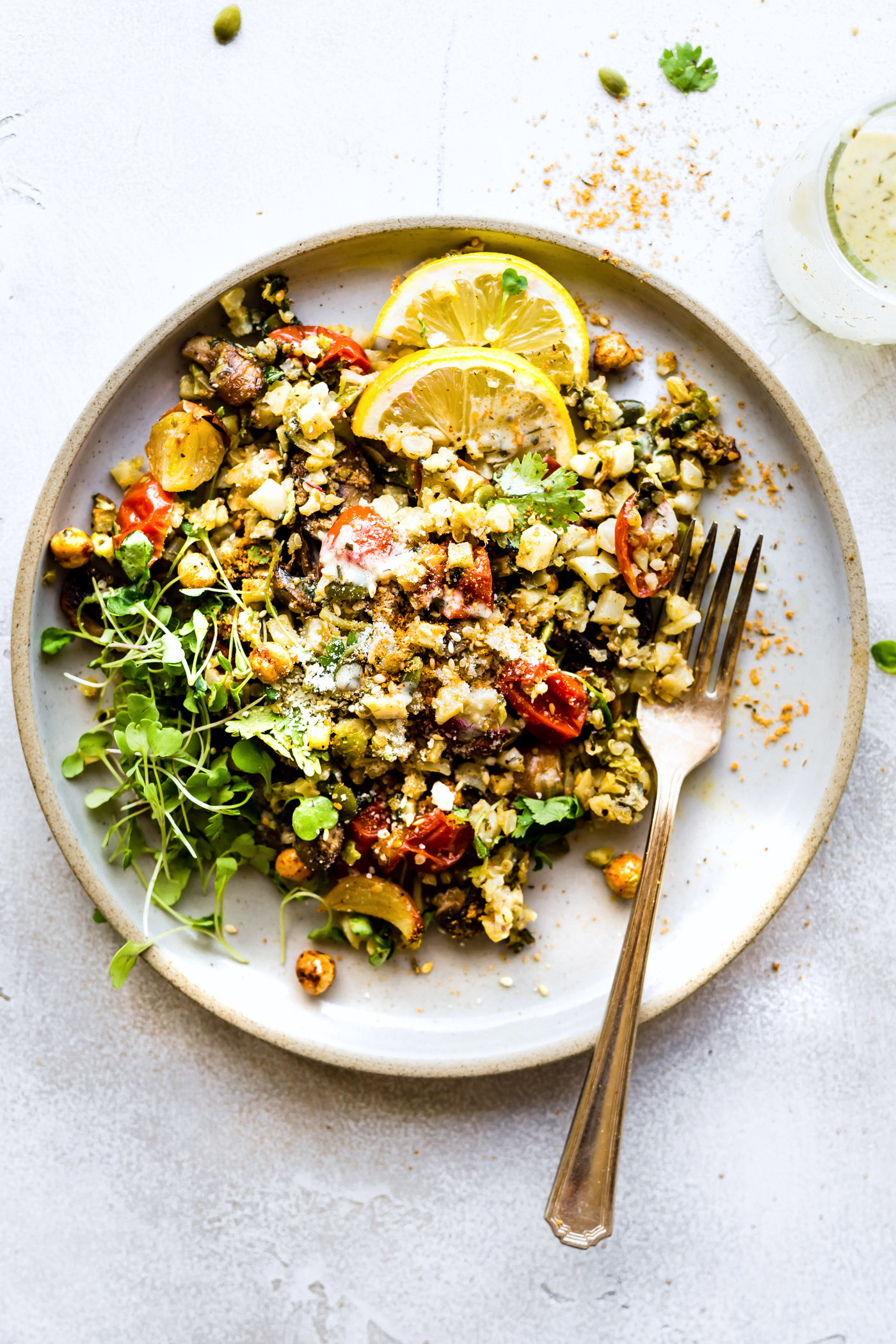 Dukkah roasted vegetables salad on stone plate with fork.