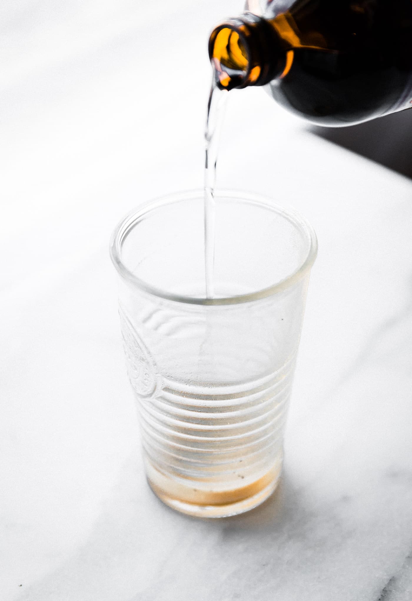 MCT oil being poured into tall glass.