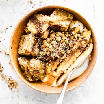 Overhead view sticky date cake yogurt bowl with silver spoon in yogurt.