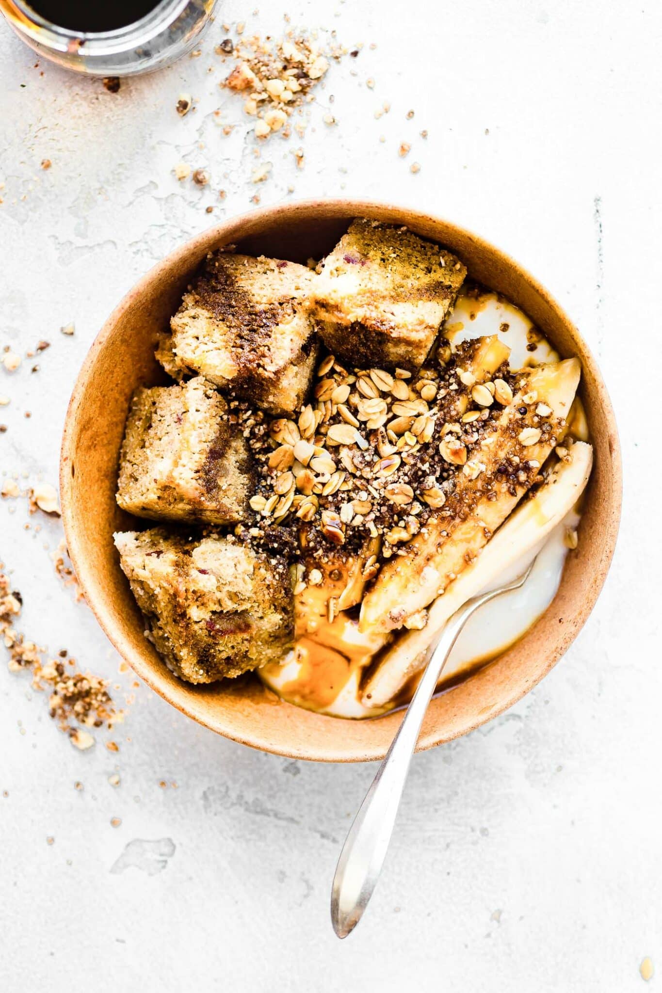 Overhead view sticky date cake yogurt bowl with spoon in yogurt.