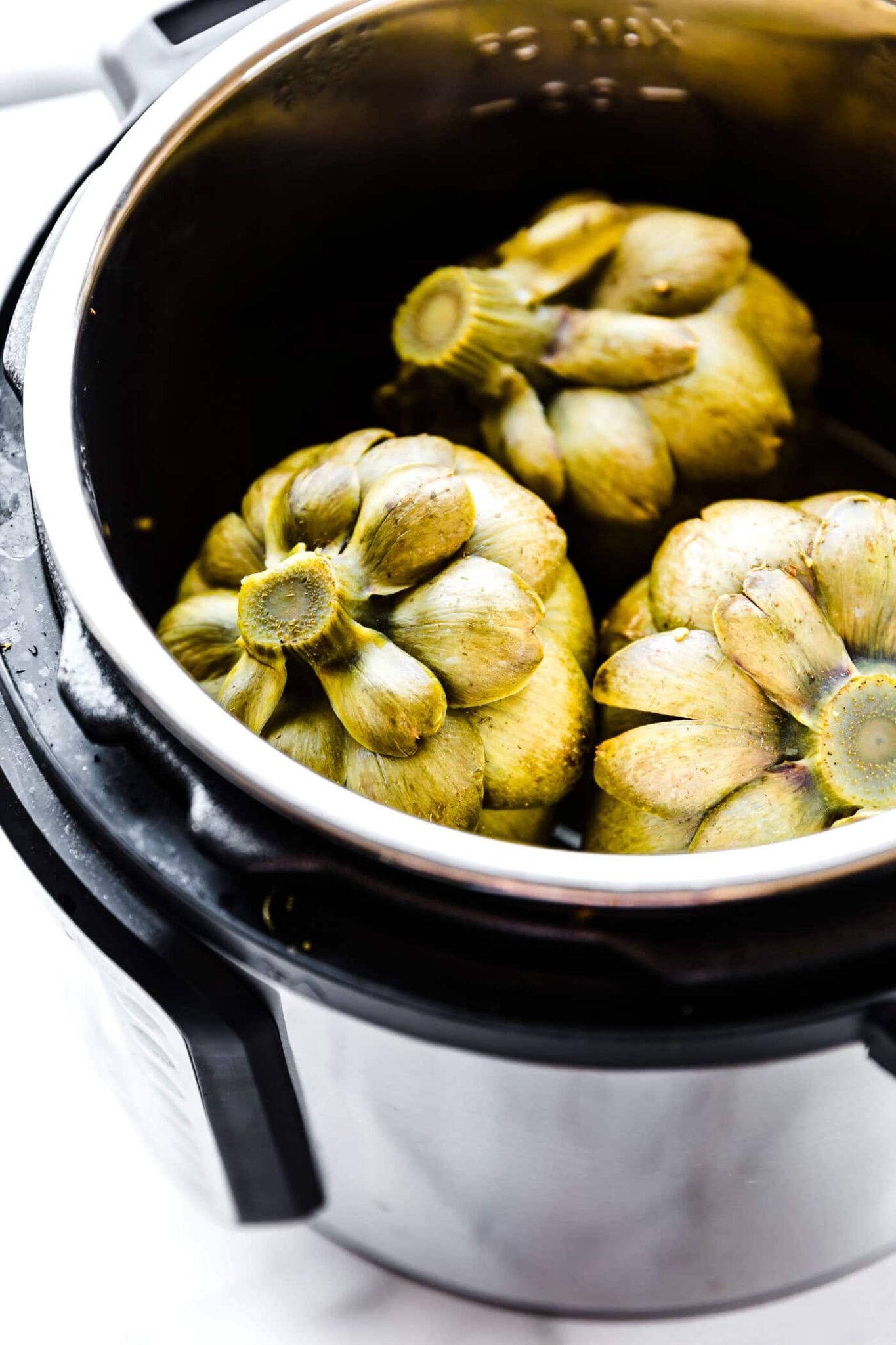 Three artichokes in an Instant Pot.