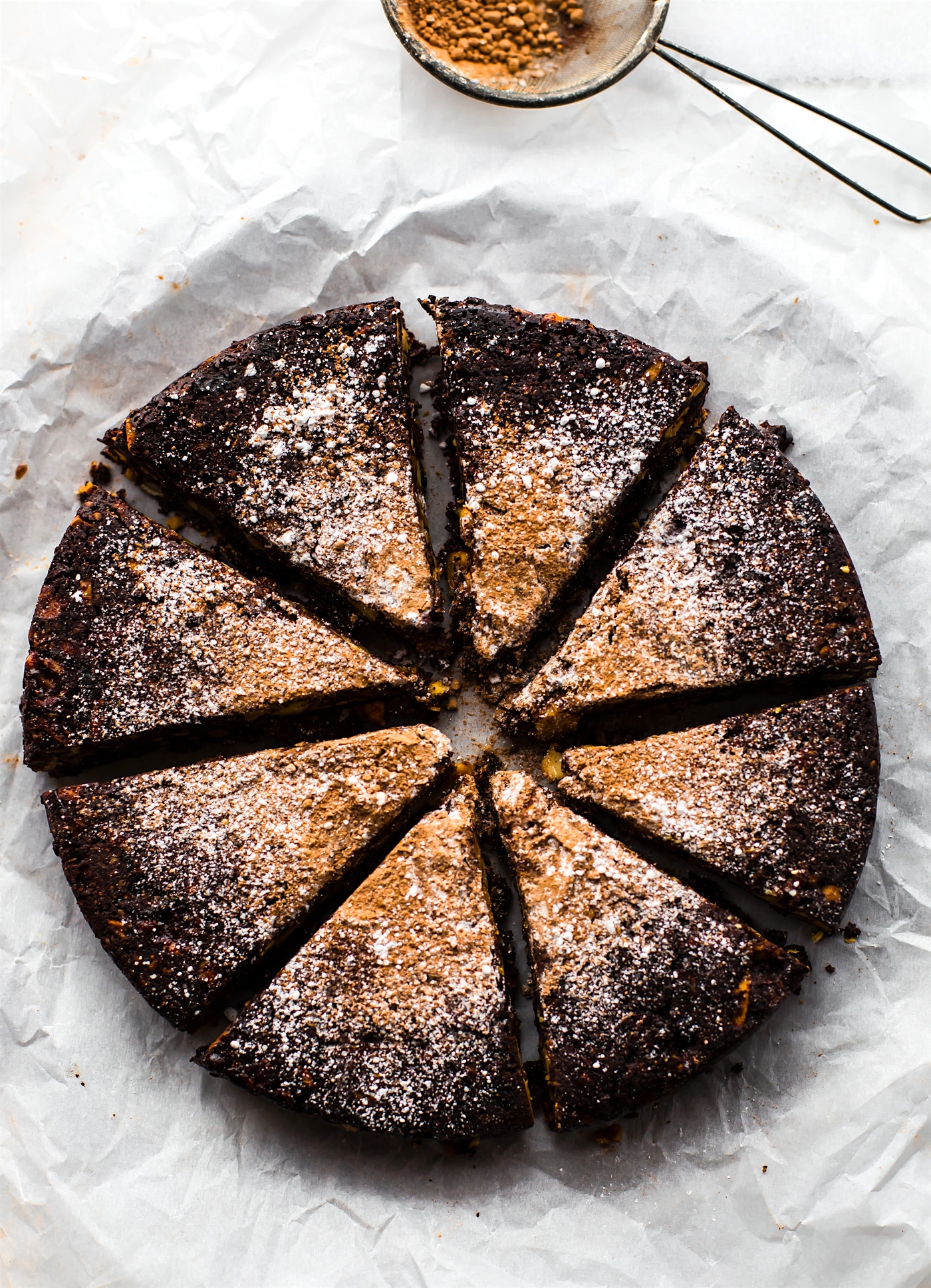 Overhead photo of gluten free Italian Christmas cake cut into slices and dusted with sugar.