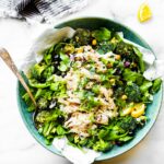 Overhead view turquoise bowl filled with no mayo chicken salad over mixed greens and broccoli