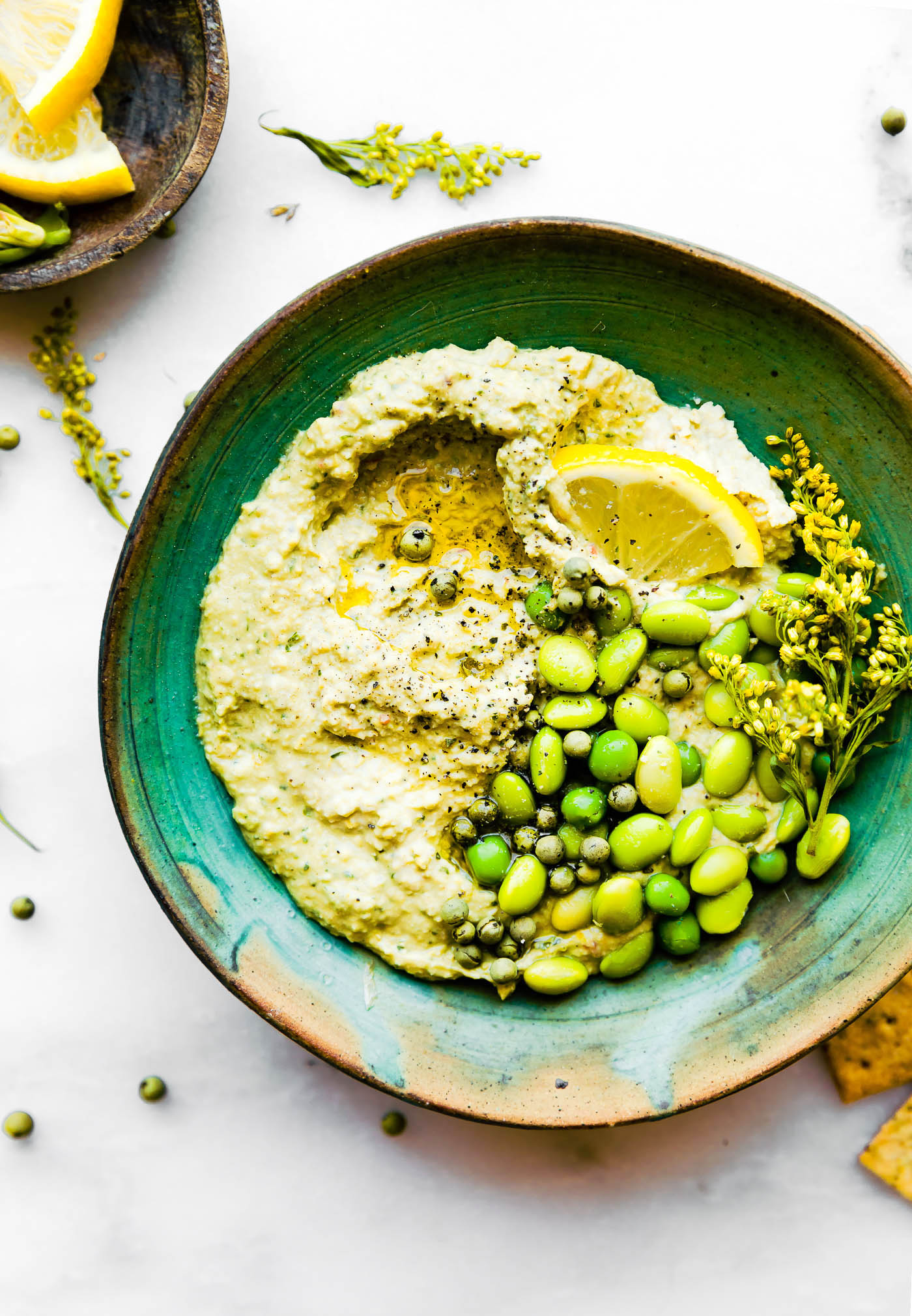 Overhead view vegan edamame pesto dip in green bowl