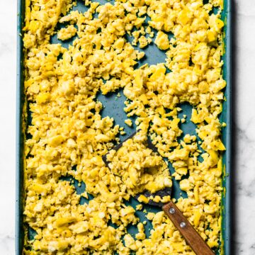 Oven scrambled eggs on a blue sheet pan.