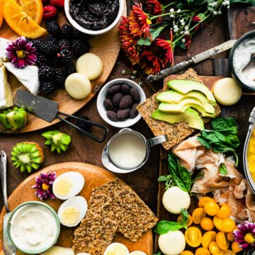 Overhead view brunch charcuterie boards filled with waffles, crackers, fresh fruit, and more