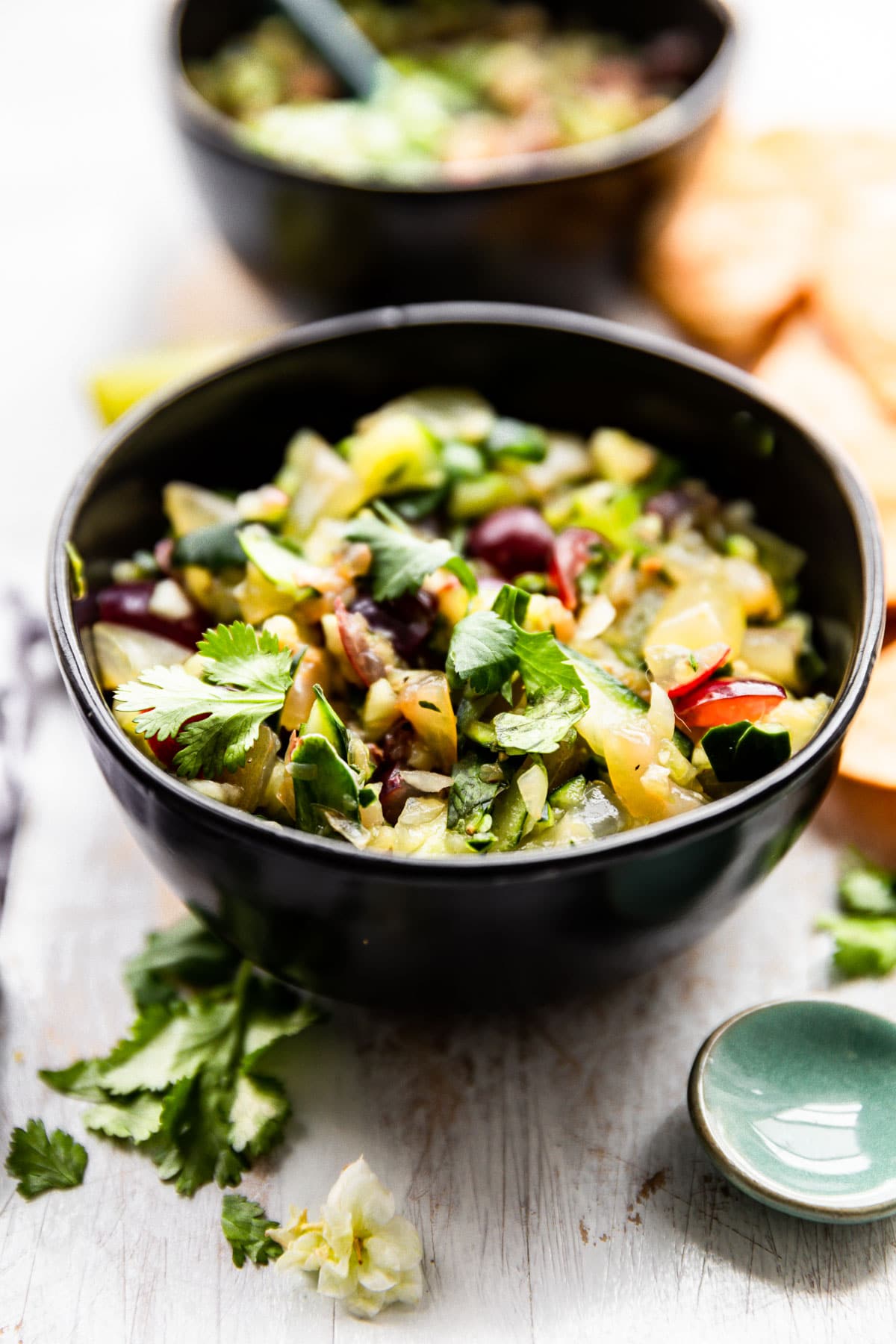 fresh salsa recipe, served in a black bowl - made with cucumbers, grapes, cilantro, and jalapeno