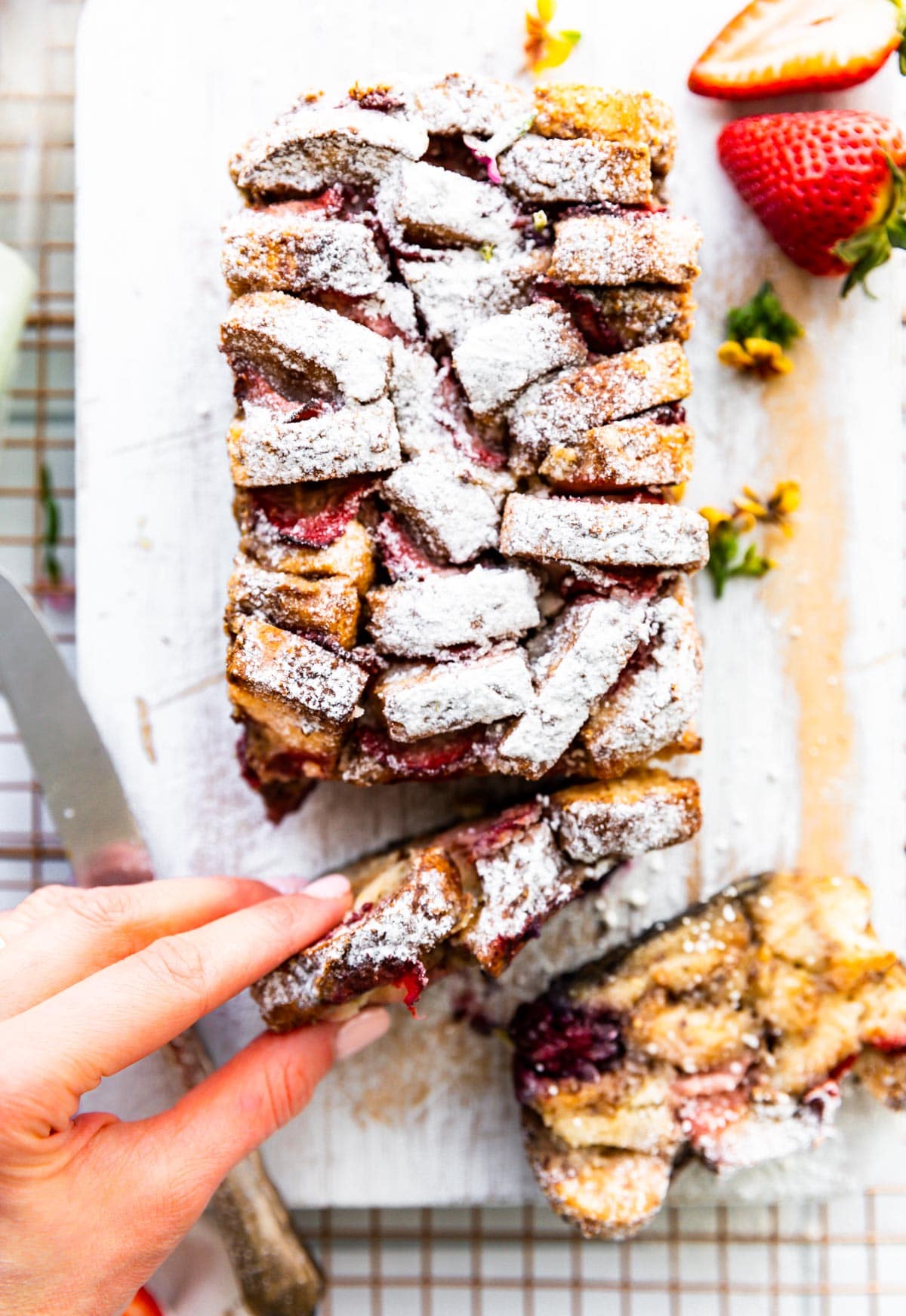 loaf of french toast bread slices with hand grabbing slice