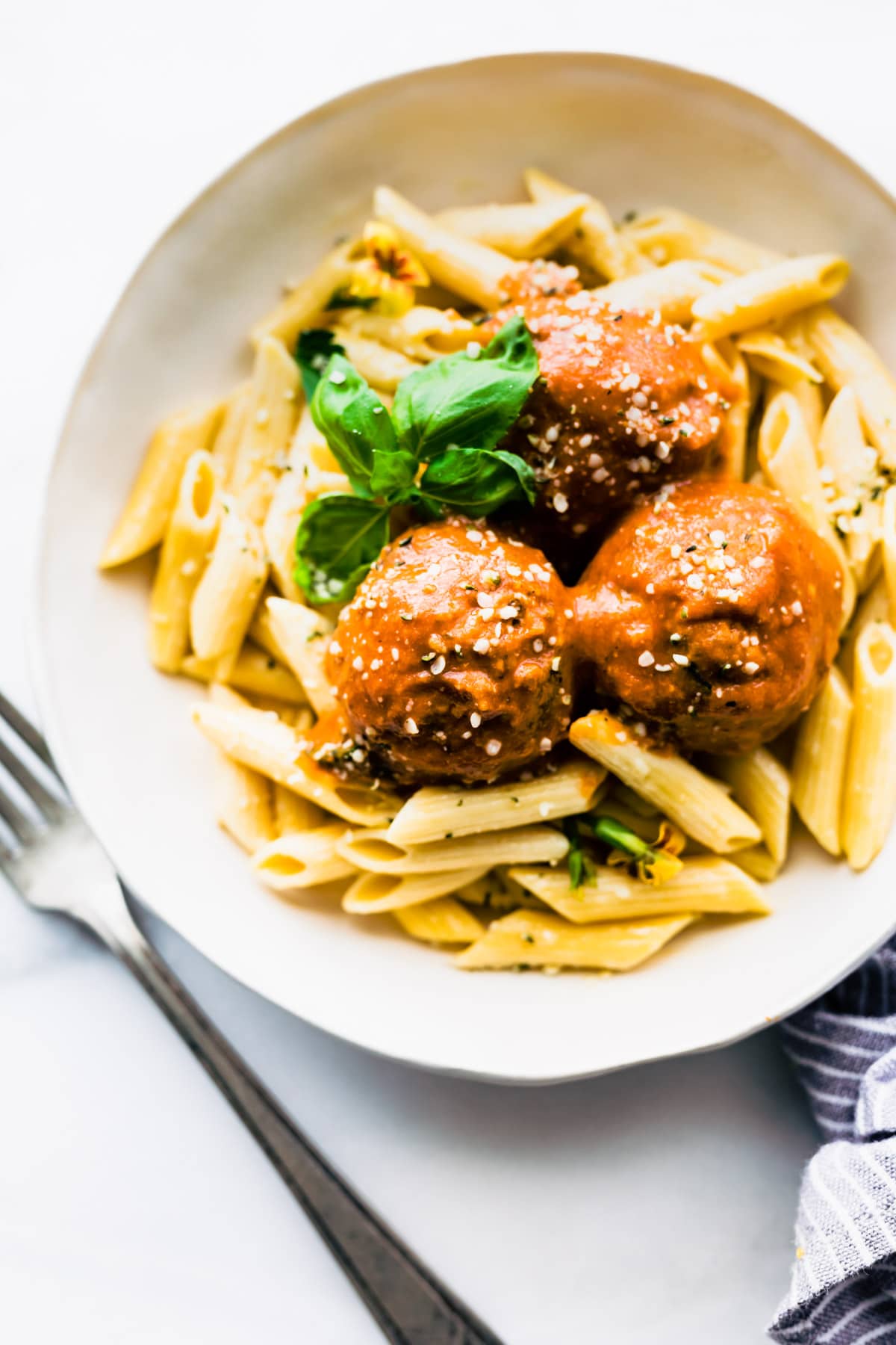Overhead view vegan meatballs on plate with ziti pasta