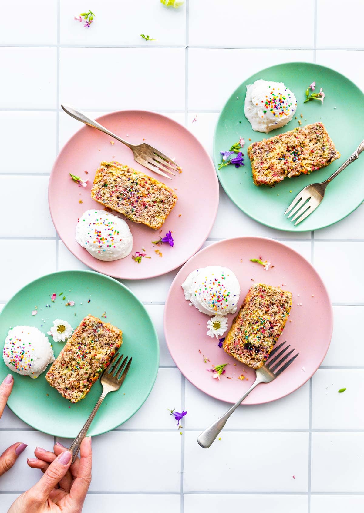 Mint green and pastel pink plates with scoops of ice cream and Funfetti cake slices.