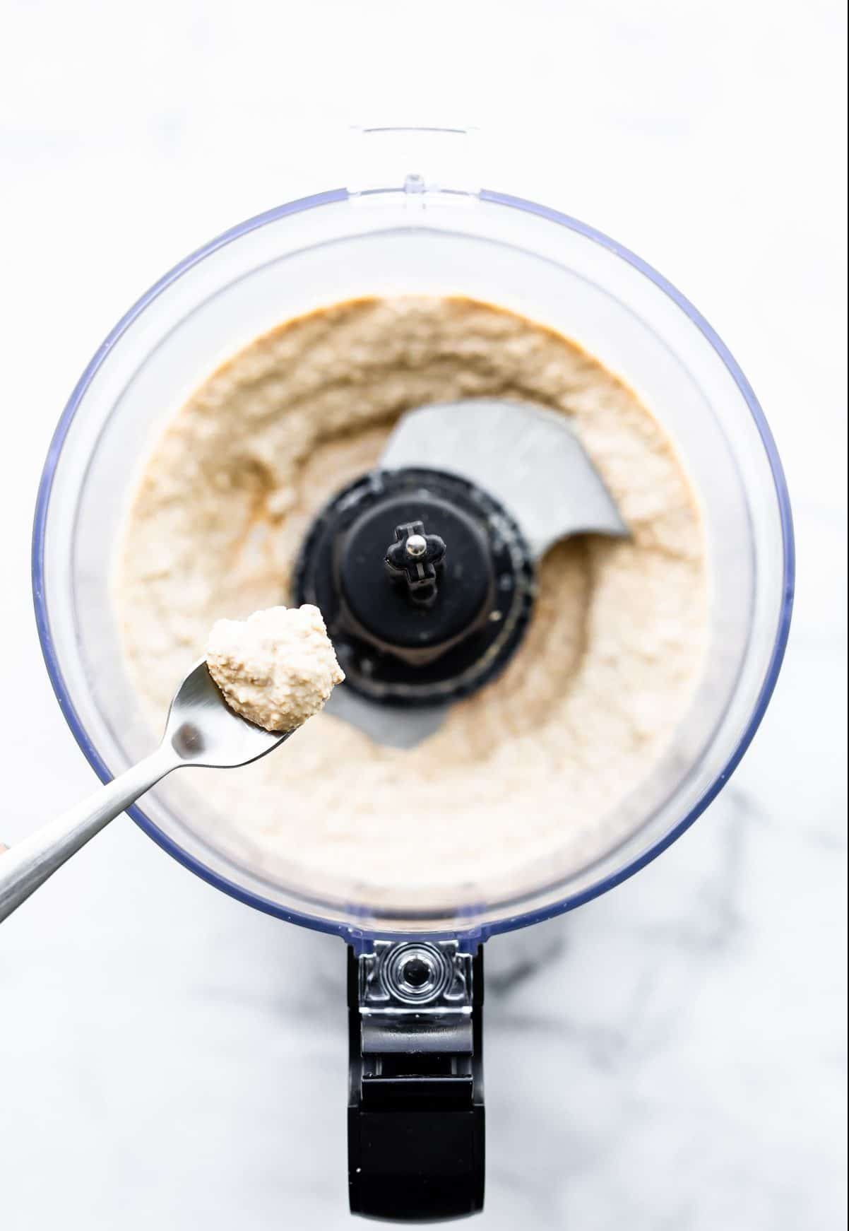 overhead photo: ingredients in food processor to make garlic walnut sauce