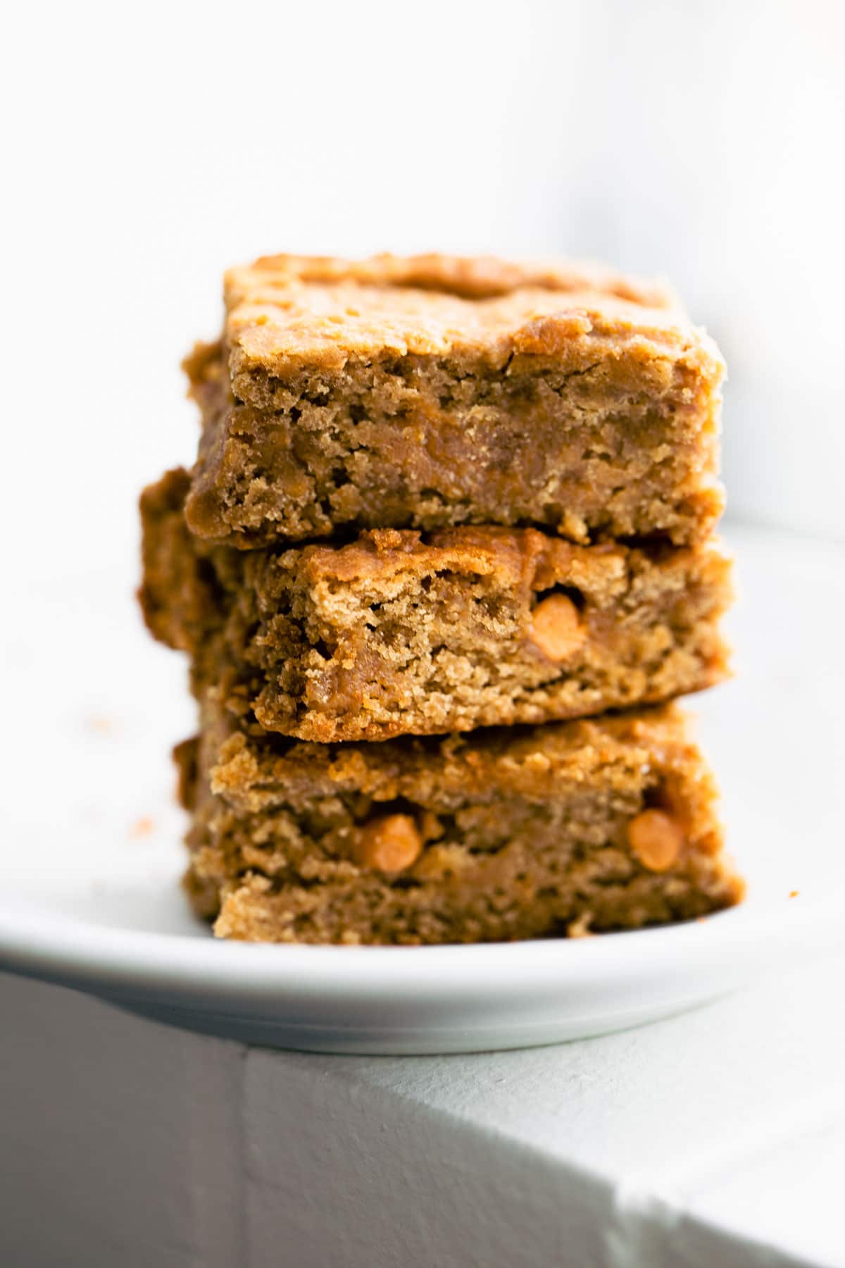 3 cinnamon chickpea blondies stacked on round white plate