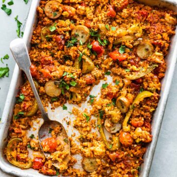 overhead photo: Serving spoon on baking sheet with Mexican cauliflower rice