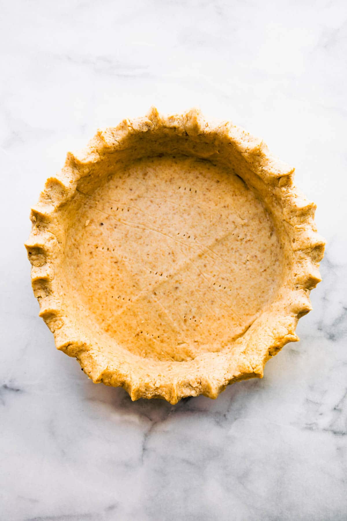 Overhead photo of homemade gluten free pie crust on gray background.