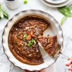 overhead photo: removing slice of sweet potato pie from white pie dish