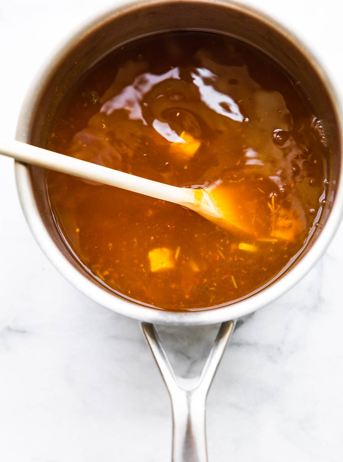 Overhead photo of homemade broth in a soup pot for Thai Chicken Soup.