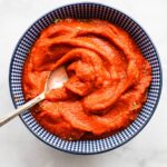 Nomato sauce in a blue and white bowl with a spoon.