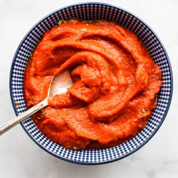 Nomato sauce in a blue and white bowl with a spoon.