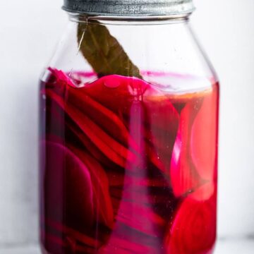 turnip pickles and bay leaf in a glass canning jar