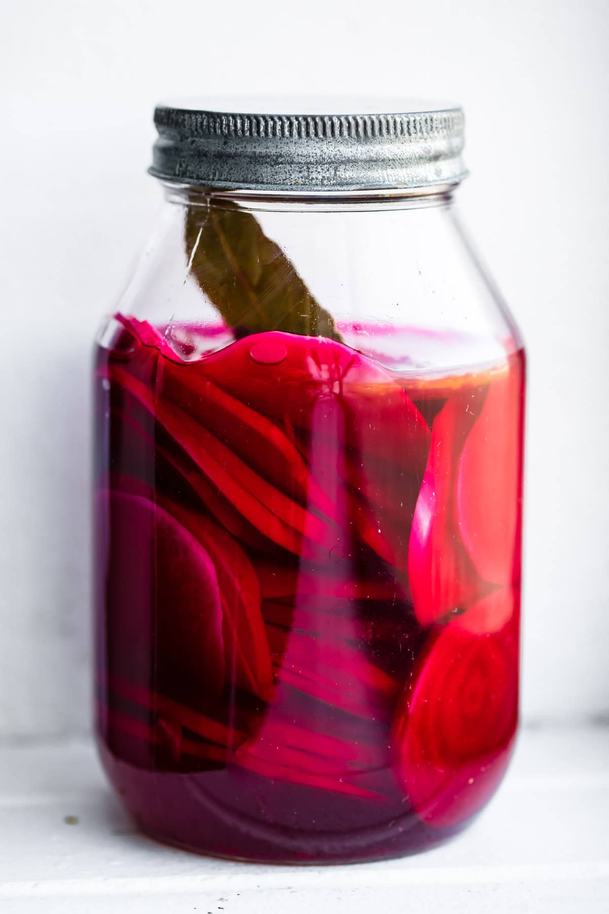 turnip pickles and bay leaf in a glass canning jar
