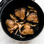 cooked lamb inside an air fryer on a white countertop