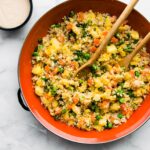 overhead image: two serving spoons in skillet of homemade healthy fried rice