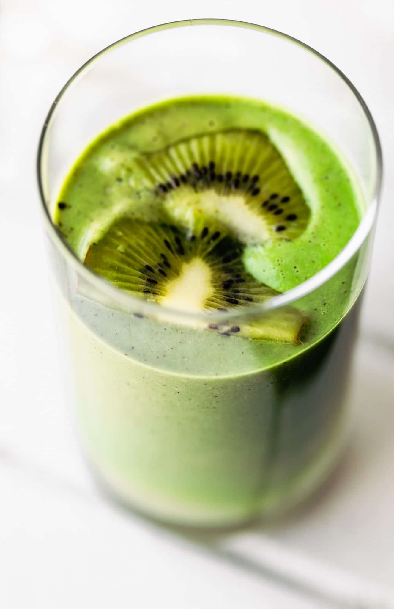 Close up image of superfood spirulina smoothie garnished with fresh kiwi.