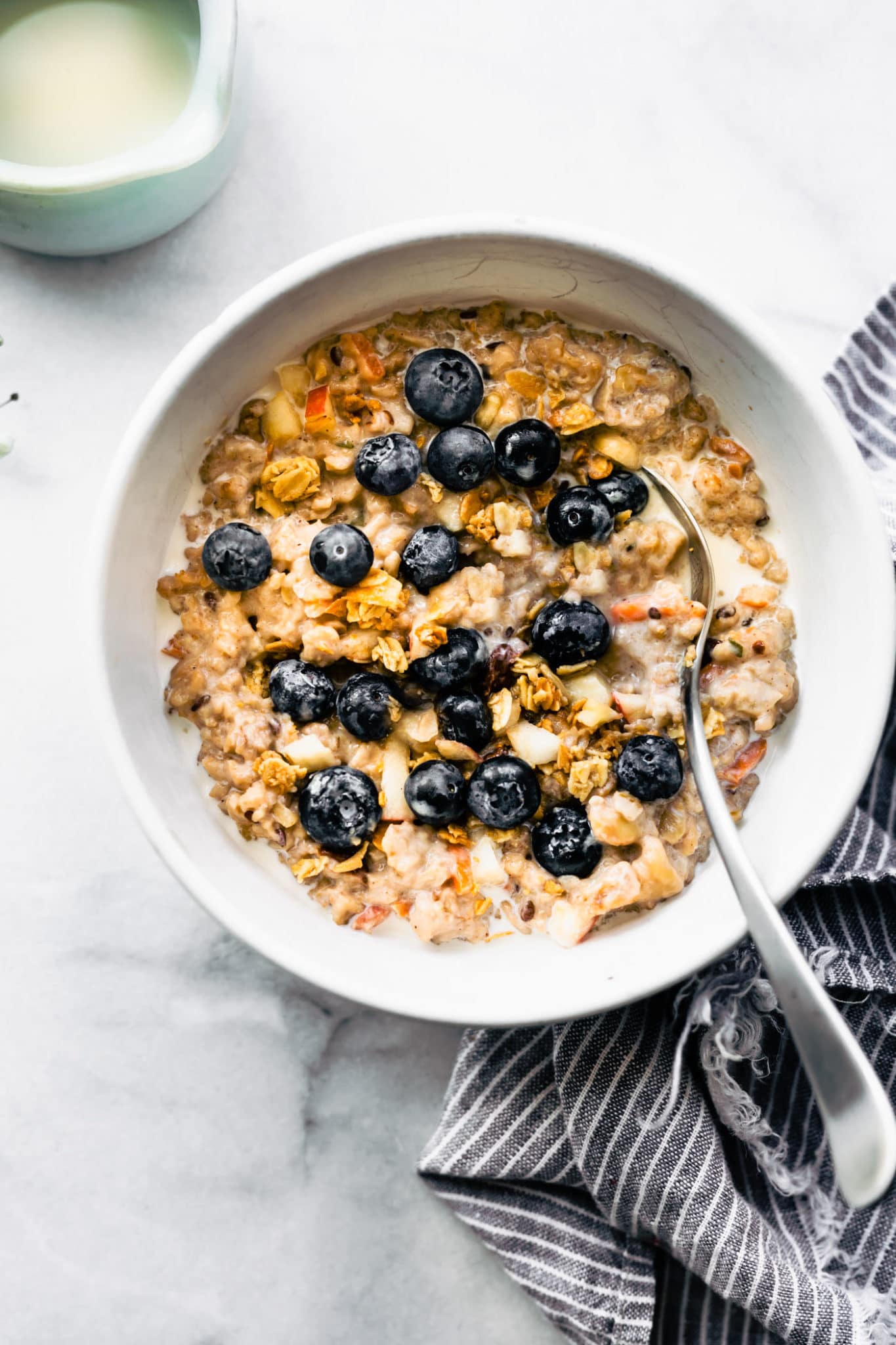 superfood instant pot oatmeal served in a white bowl topped with fresh blueberries and served with a spoon