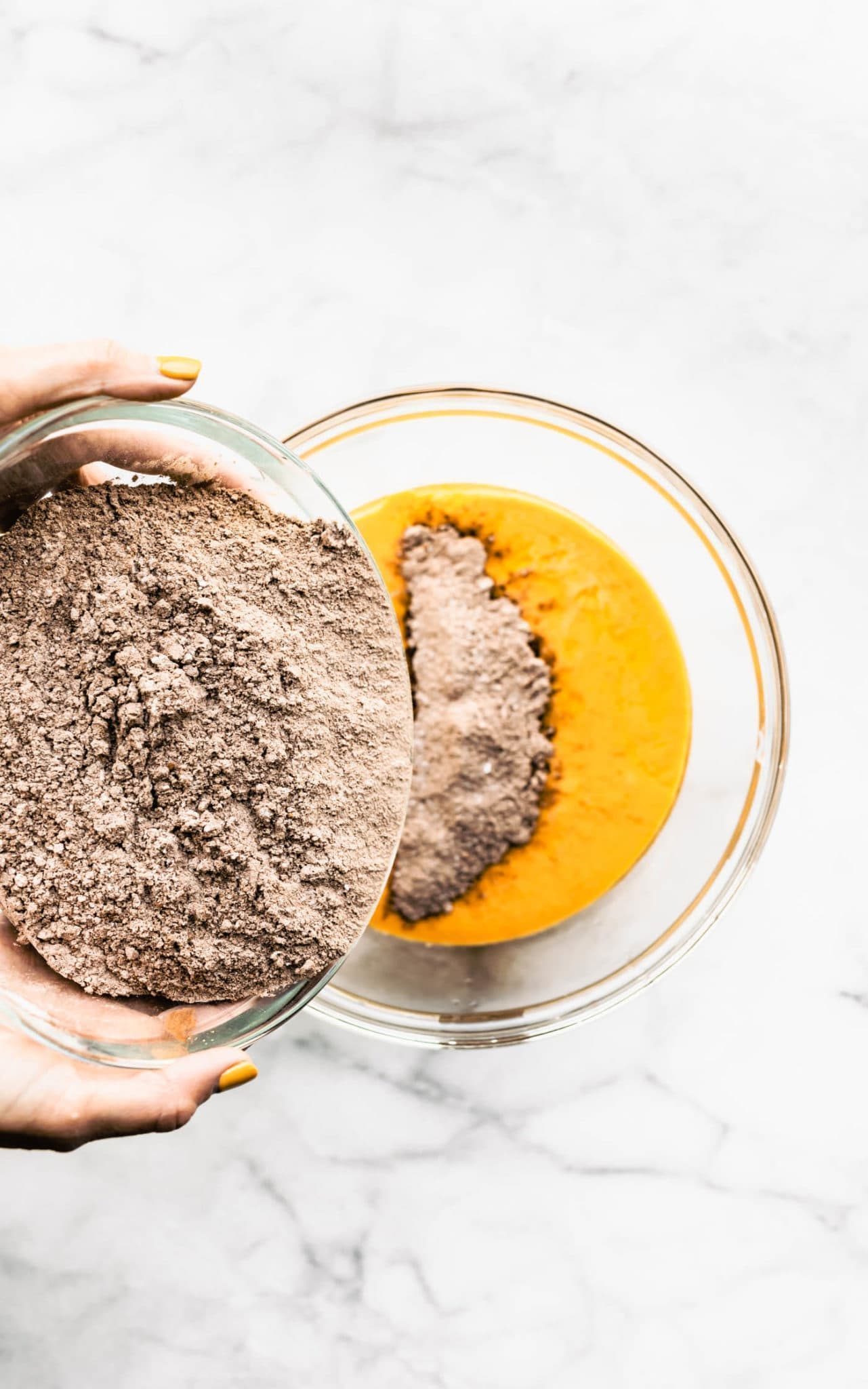 Dry ingredients poured into wet ingredients for vegan chocolate cupcakes.