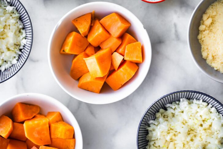 sweet potatoes, reiced cauliflower, and ingredients for sweet potato tots in mixing bowls