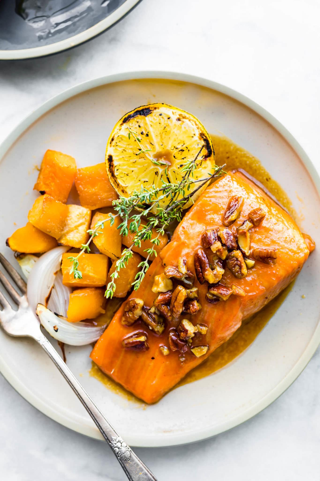 Up close photo of maple bourbon glazed salmon and veggies on a plate.