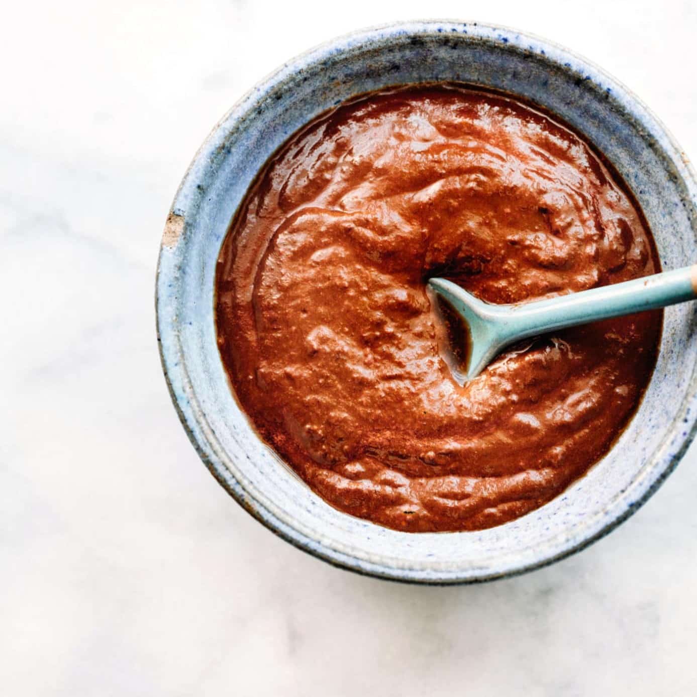 Homemade mole sauce in a small bowl with a spoon